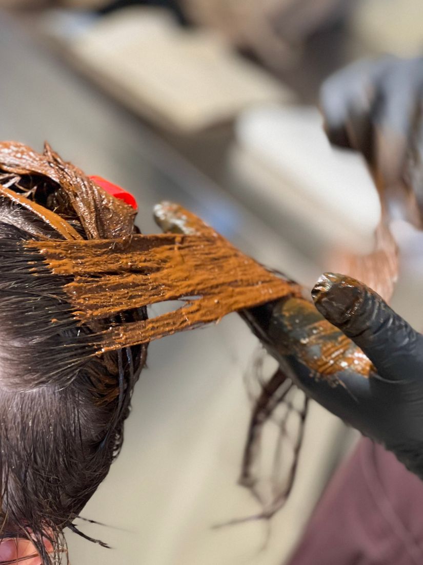 Plant-based clay colour being applied to the hair