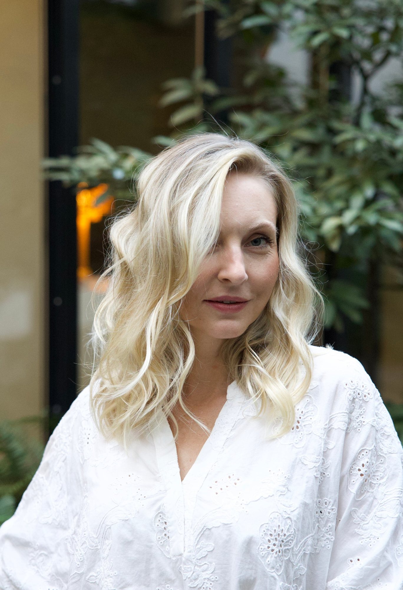 A client with soft blonde waves in the Studio Rafael garden