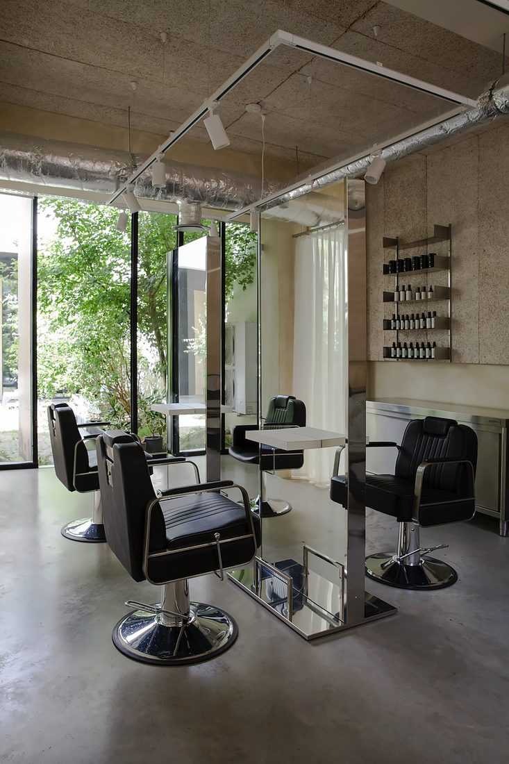 Salon chairs and steel mirrors in front of the garden windows